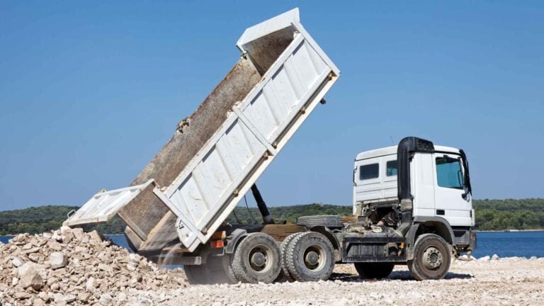 Tipper truck unloading aggregate at a construction site